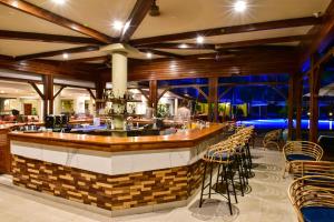 蒙舒瓦西Tarisa Resort & Spa的餐厅内的酒吧,配有桌椅