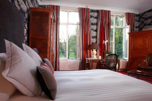 赫黑维尔达多门尼勒城堡酒店的卧室配有带枕头的床铺和窗户。