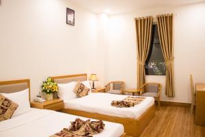 波来古市Hoài Thương Hotel的酒店客房设有两张床和窗户。