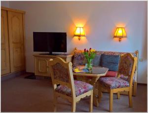 奥泊维森塔尔洛特斯旅馆的客厅配有桌子、沙发和电视
