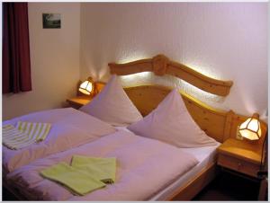 奥泊维森塔尔洛特斯旅馆的床上有两把绿色的餐巾