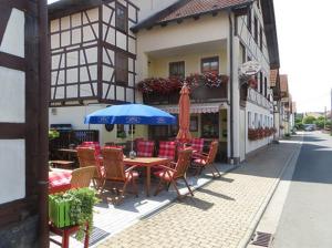 RiethGasthaus Beyersdorfer的街上的一张桌子和椅子上摆放着蓝色遮阳伞