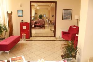 亚历山德鲁波利斯希里酒店的一间带红色沙发的客厅和一间客厅