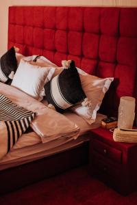 El GoueraDesert Luxury Camp Erg Chigaga的一张带红色床头板和枕头的床