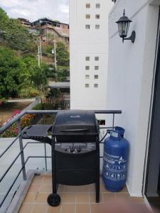 圣菲德安蒂奥基亚Ciudadela Santafe的阳台上的烧烤架,配有水箱