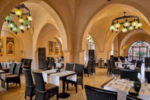 考拉亚湾达伊尔梅迪纳度假村的餐厅设有桌椅和吊灯。