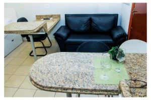 戈亚尼亚Flats Service Bueno的客厅配有沙发和带酒杯的桌子