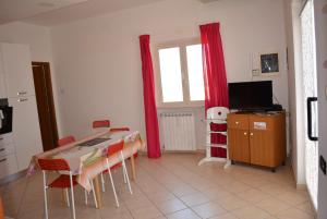 AriAppartamento Arione的厨房配有桌椅和电视。