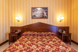 博尔塞纳利都酒店的一间卧室配有一张带2个床头柜和2盏灯的床。