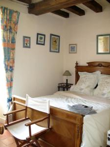 Jarzé拉美思纳赫里酒店的一间卧室配有一张木床和一把椅子