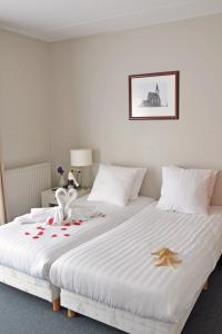 登堡Hotel Koogerend的一间卧室配有两张红色玫瑰床。