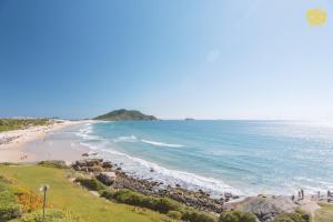 弗洛里亚诺波利斯Costao do Santinho Resort All Inclusive的海滩上有人在沙滩上散步