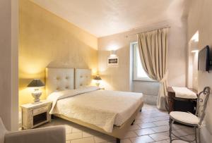 特雷斯努拉吉斯Il Cortiletto Hotel Maison的一间卧室设有一张大床和一个窗户。