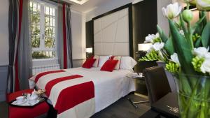 罗马杜卡德阿尔巴酒店的酒店客房的床铺配有红色和白色的床单