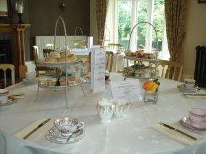 赫里福德The Priory的一张桌子,上面有白色的桌布,上面有蛋糕和糕点