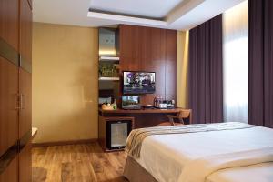 名古屋维也纳精品酒店的一间卧室配有一张床、一张书桌和一台电视