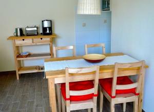ZirchowFerienwohnung Fam. Gansau - Insel Usedom的厨房配有木桌、椅子和桌子。