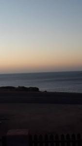 吕德里茨Seabreeze Accommodation的日落时从海滩欣赏到海景