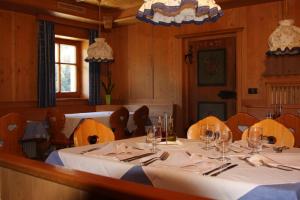 瓦尔道拉Berggasthof Trattes的用餐室配有桌椅和酒杯