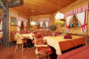 温特埃特维恩特洛尔酒店的一间设有两张桌子和红色椅子的用餐室