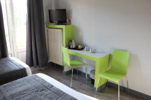 斯特拉斯堡Hotel Esplanade的客房设有一张桌子、两把椅子和一台电视。