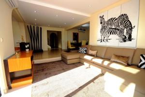 阿尔布费拉Villa Carlivo的客厅配有沙发,墙上有2个斑马