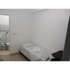 皮拉西卡巴Anexo São João的白色的客房设有一张床和一个卫生间。