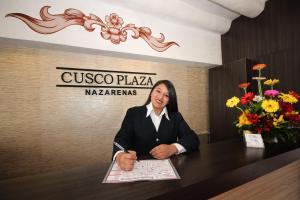 库斯科Cusco Plaza Nazarenas的坐在桌子上的妇女,用纸