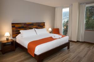 基多Ilalo Garden Hotel & Restaurant的一间卧室设有一张大床和一个大窗户