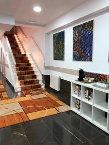 毕尔巴鄂Pensión Miribilla的一间设有楼梯的客房,墙上挂有绘画作品