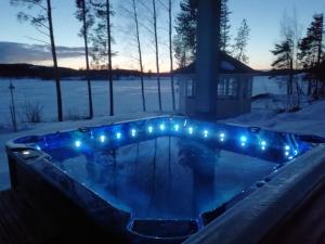 MelkoniemiJacuzzi Rantakallio的雪中带灯光的按摩浴缸