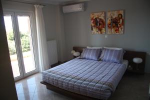 普希里阿莫斯Thalatta Seaside Accommodation的一间卧室设有一张床和一个玻璃门