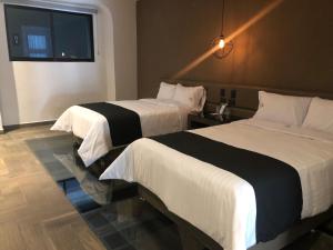 普埃布拉Hotel Isabel的酒店客房设有两张床和窗户。