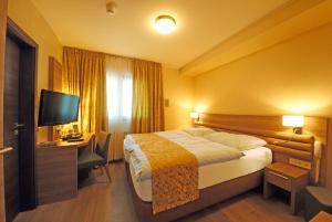 布尔沙伊德圣费亚科酒店的酒店客房配有一张床、一张书桌和一台电视。