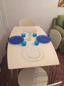 阿尔姆尼卡Has encontrado lo que buscabas...的一张带蓝色板子和玻璃杯的白色桌子