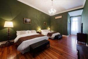 圣伊西德罗德尔卡斯科酒店的卧室设有两张床,拥有绿色的墙壁和木地板