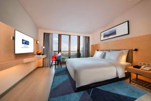 北京北京首钢工舍智选假日酒店的酒店客房设有一张大床和一张书桌。