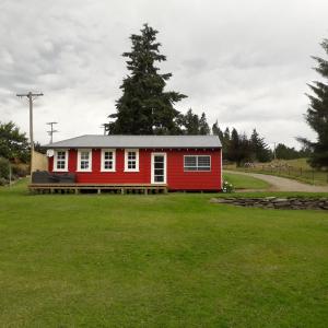 奥玛鲁Little Red School House的绿色田野中间的红色房子