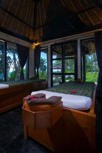 芒希Mangsit Suites by Holiday Resort Lombok的一间卧室设有一张大床和窗户。