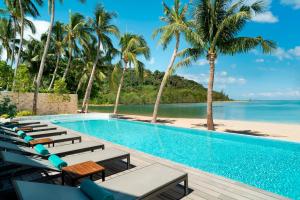 塔林甘海滩Avani Plus Samui Resort的一个带躺椅的游泳池和海滩
