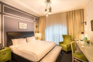 巴库Dondar Hotel Formula 1 View的酒店客房,配有一张床和一把绿色椅子