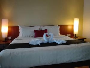 巴东马士力Langkawi Lagoon Hotel Resort的两个天鹅坐在床上