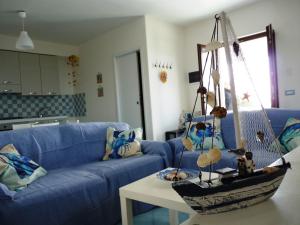 利帕里Casa Tramonto的客厅配有蓝色的沙发和桌子上的船