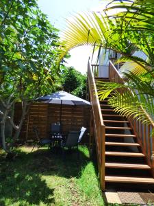 埃唐萨莱莱班海滩Bel appartement spacieux的庭院配有遮阳伞和桌椅。