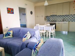 利帕里Casa Tramonto的一间带蓝色沙发的客厅和一间厨房