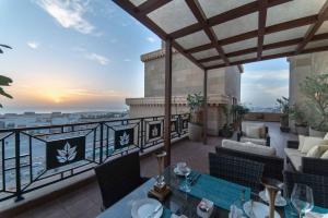 阿可贺巴Warwick Al Khobar的阳台配有桌椅,享有海景。