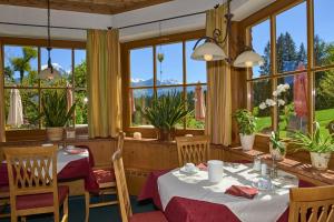 比绍夫斯维森汉德斯瑞泰尔何恩阿尔卑斯酒店的用餐室设有桌椅和窗户。