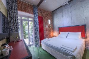 沃罗涅什Авторский Отель Бронзовый Кабан的一间卧室设有一张大床和砖墙