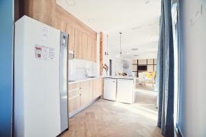 托莱多La Balconada de Toledo - PARKING GRATIS - 2 HABITACIONES的厨房配有木制橱柜和白色冰箱。