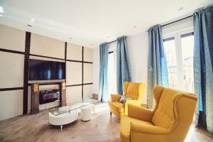 托莱多La Balconada de Toledo - PARKING GRATIS - 2 HABITACIONES的客厅配有2把黄色椅子和电视